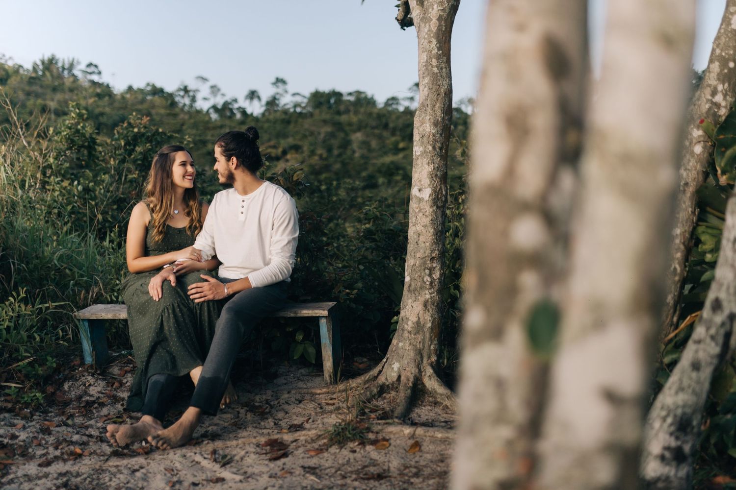 Couple enjoying a peaceful moment together on rocky terrain surrounded by trees.