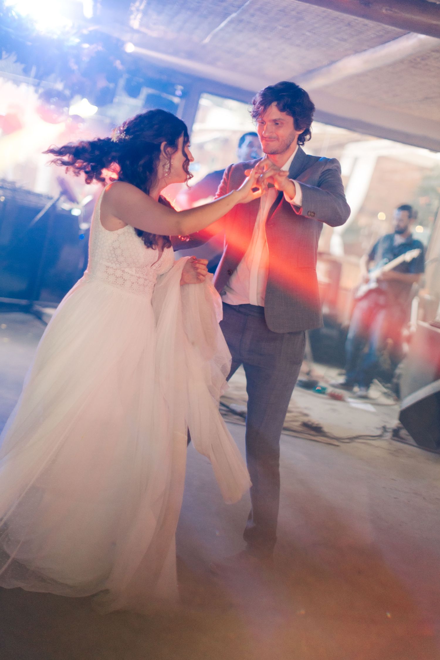 Couple performing an elegant dance move in soft lighting.