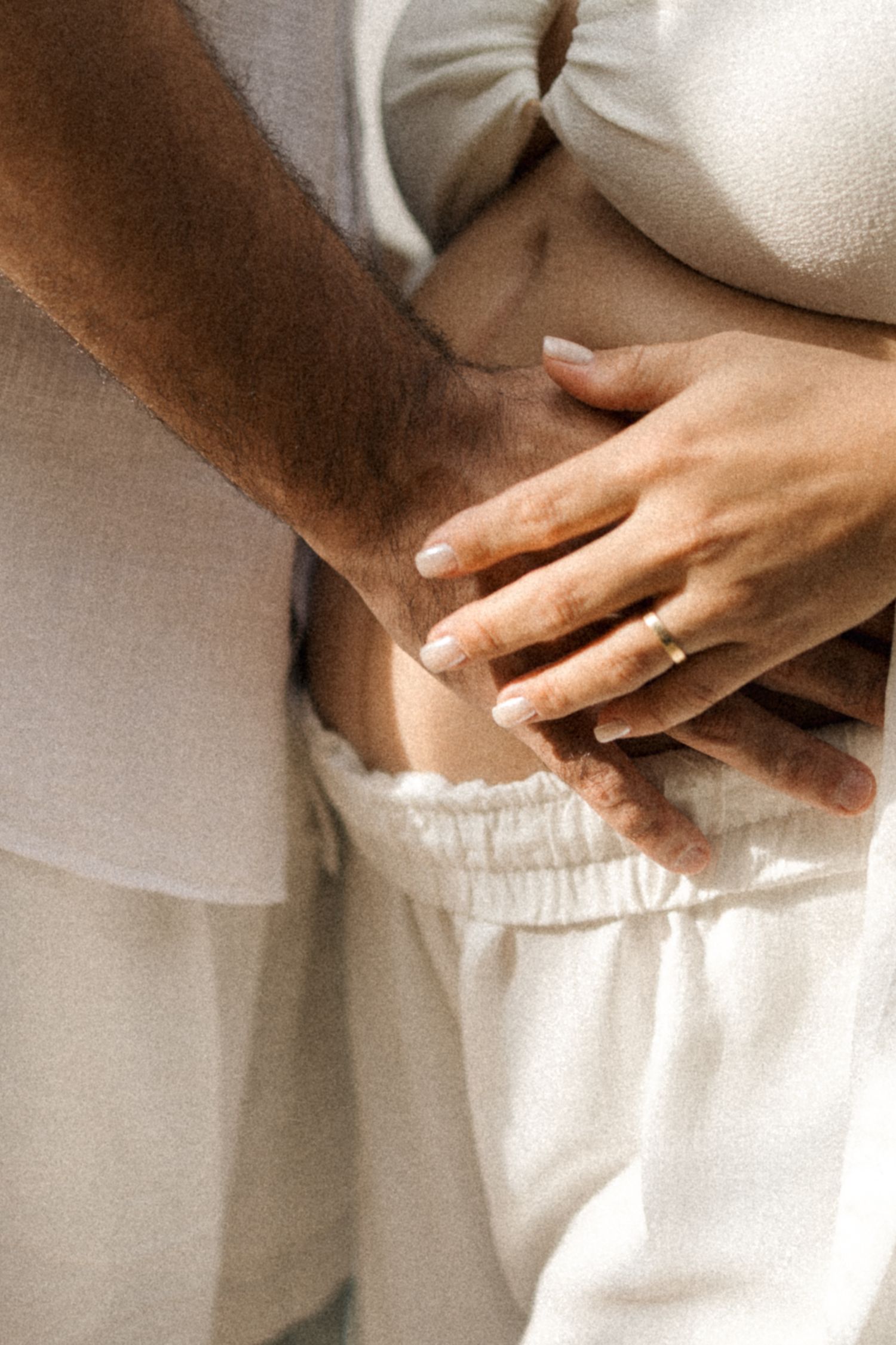 A series of cropped images showing hands resting on white fabric in warm, neutral tones.