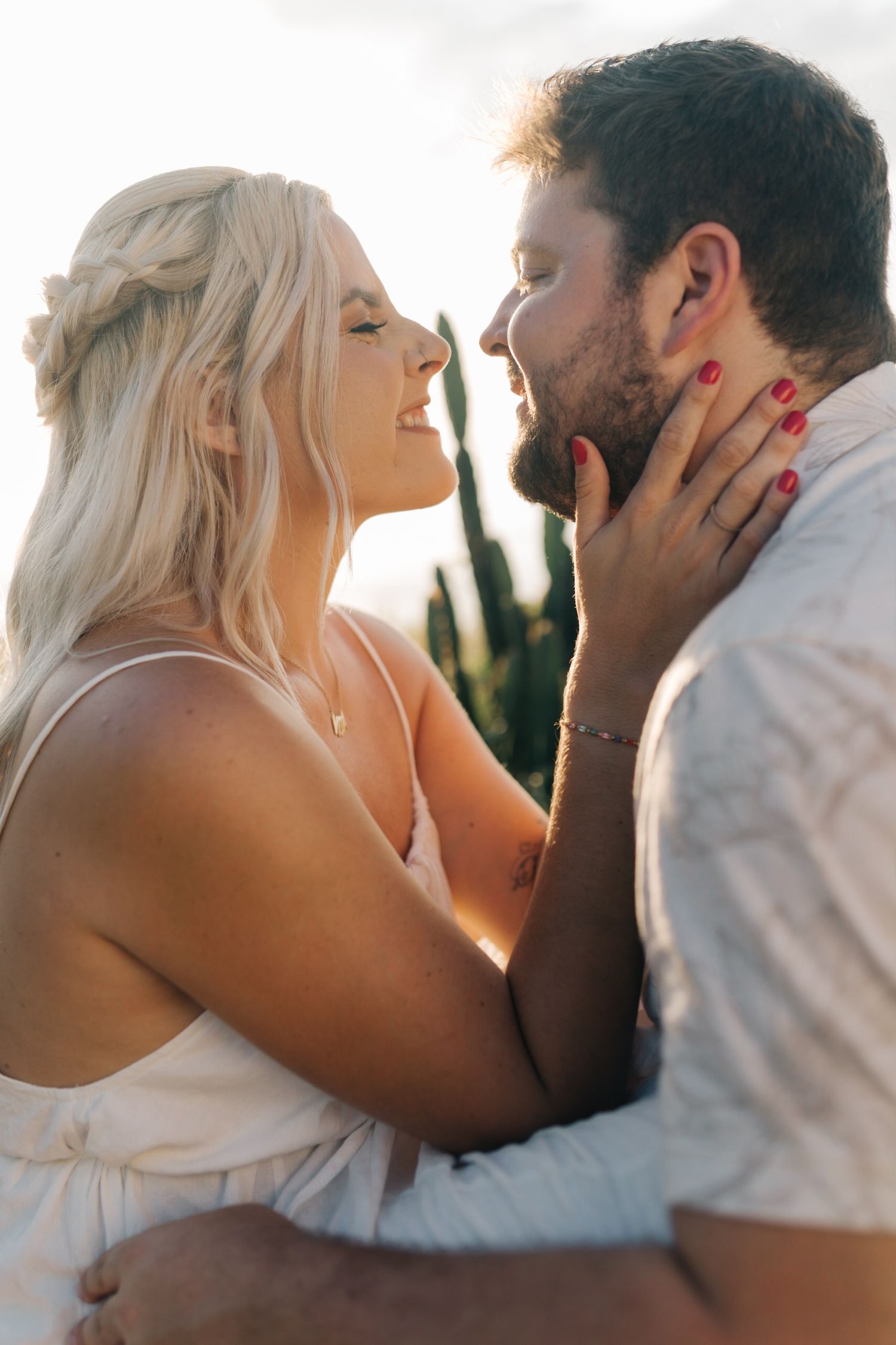 A joyful candid moment between a couple sharing laughter in the afternoon sun.