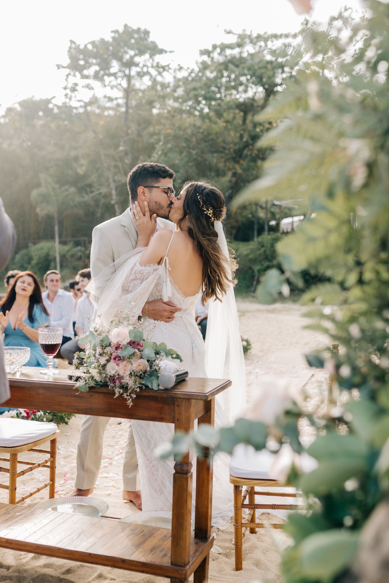 Intimate wedding celebration moment on rustic wooden table with floral decorations.