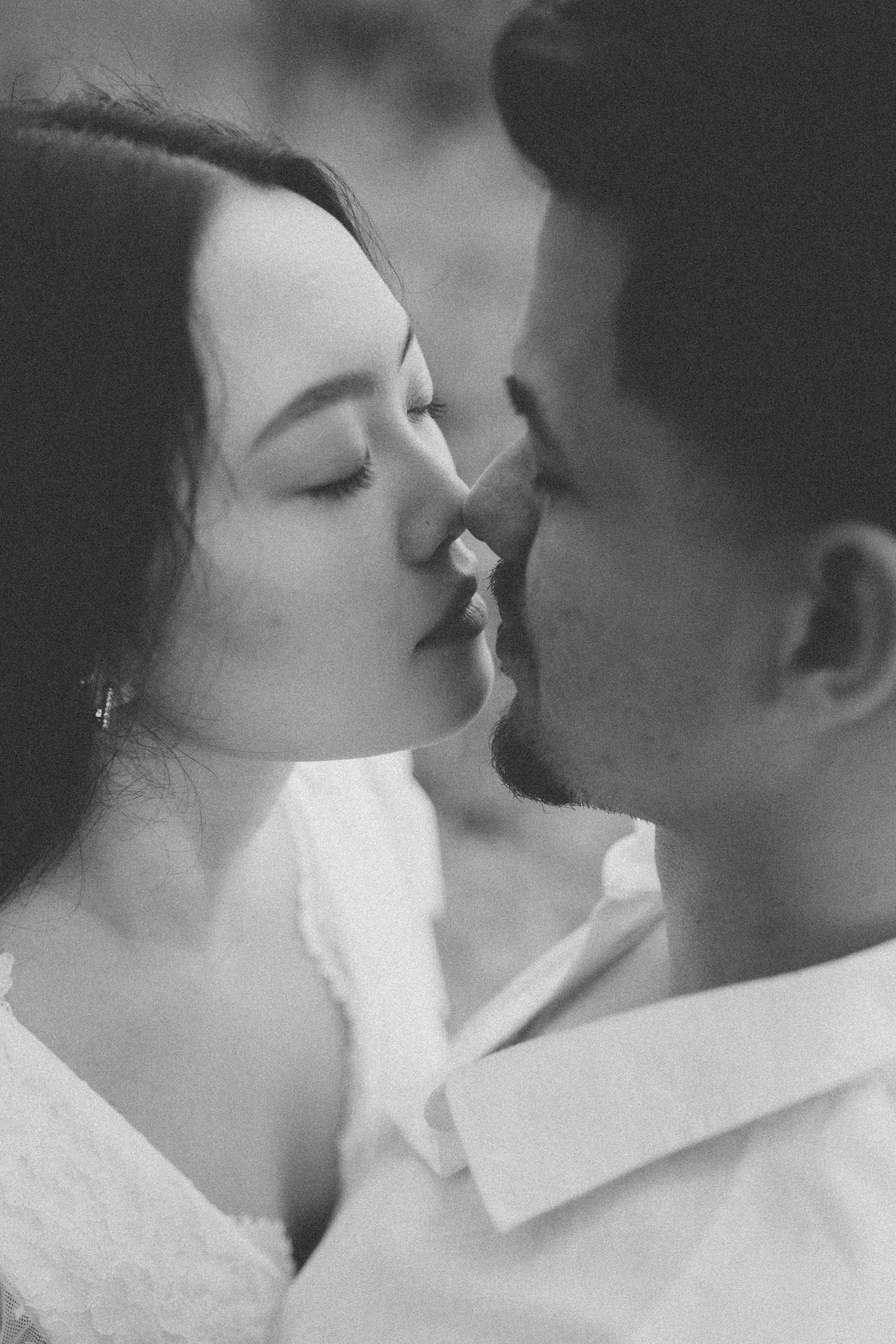 An intimate black and white portrait of a couple sharing a romantic moment.