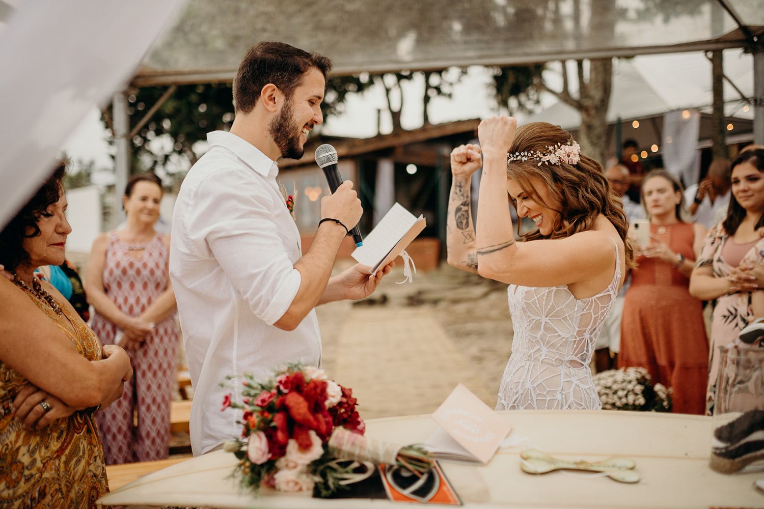 A joyful wedding celebration moment on the beach with guests watching.