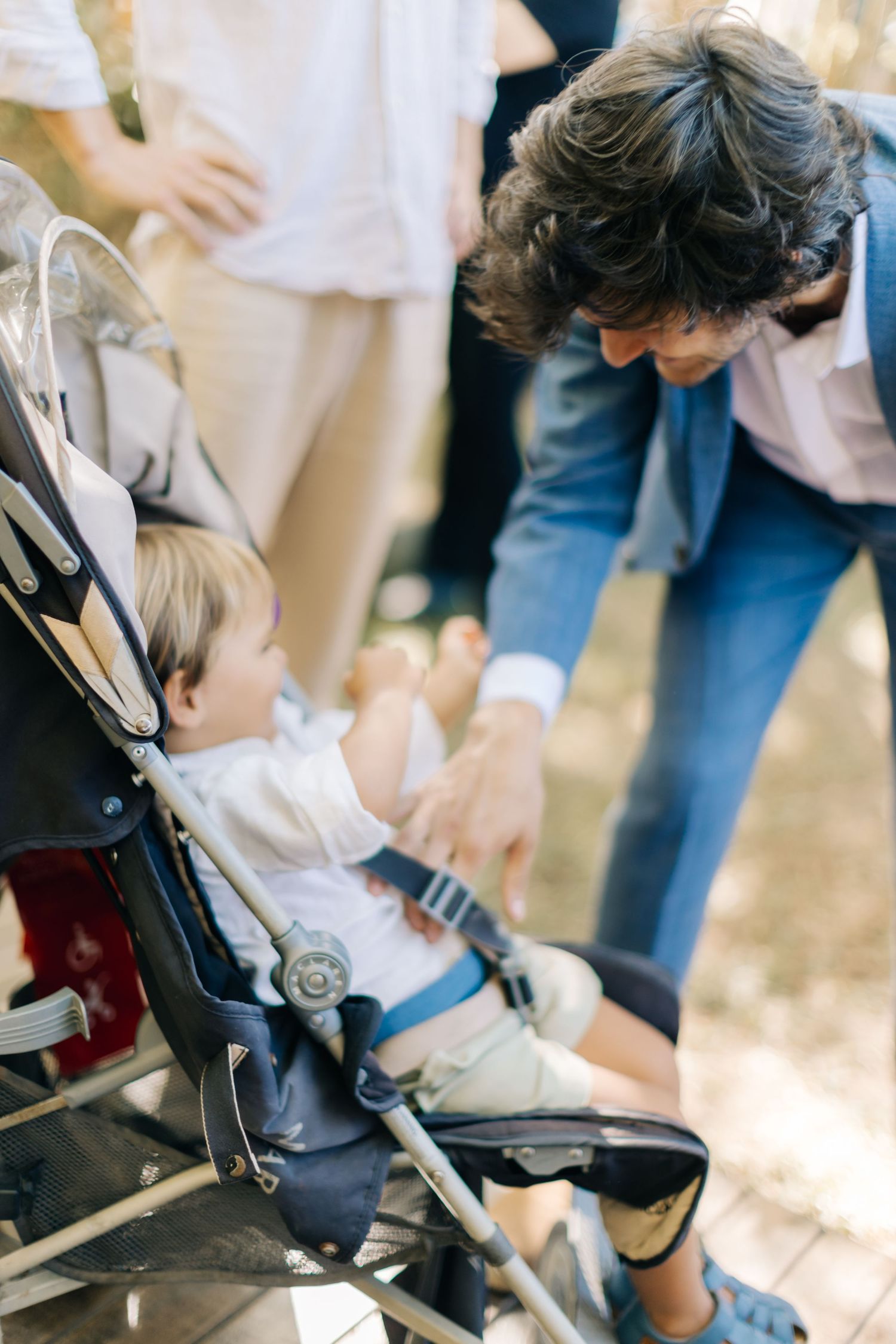 A child being secured into a stroller with safety straps and buckles.