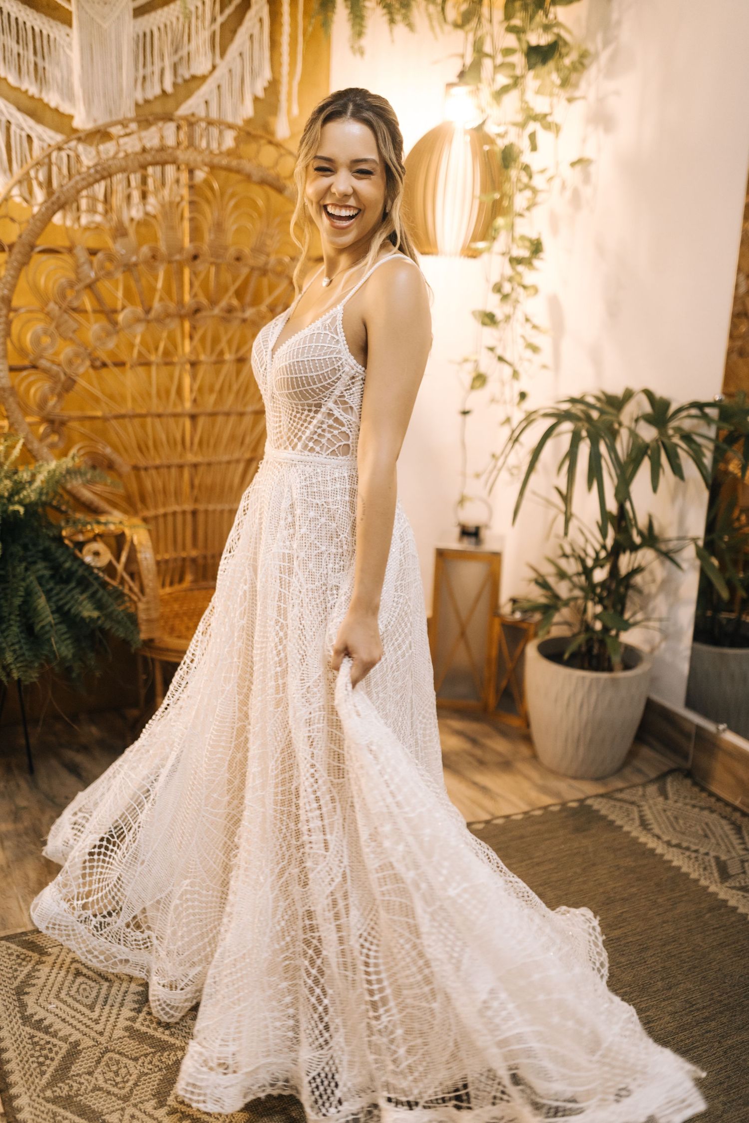 A white lace wedding dress with intricate detailing twirls in a beautifully lit garden setting.