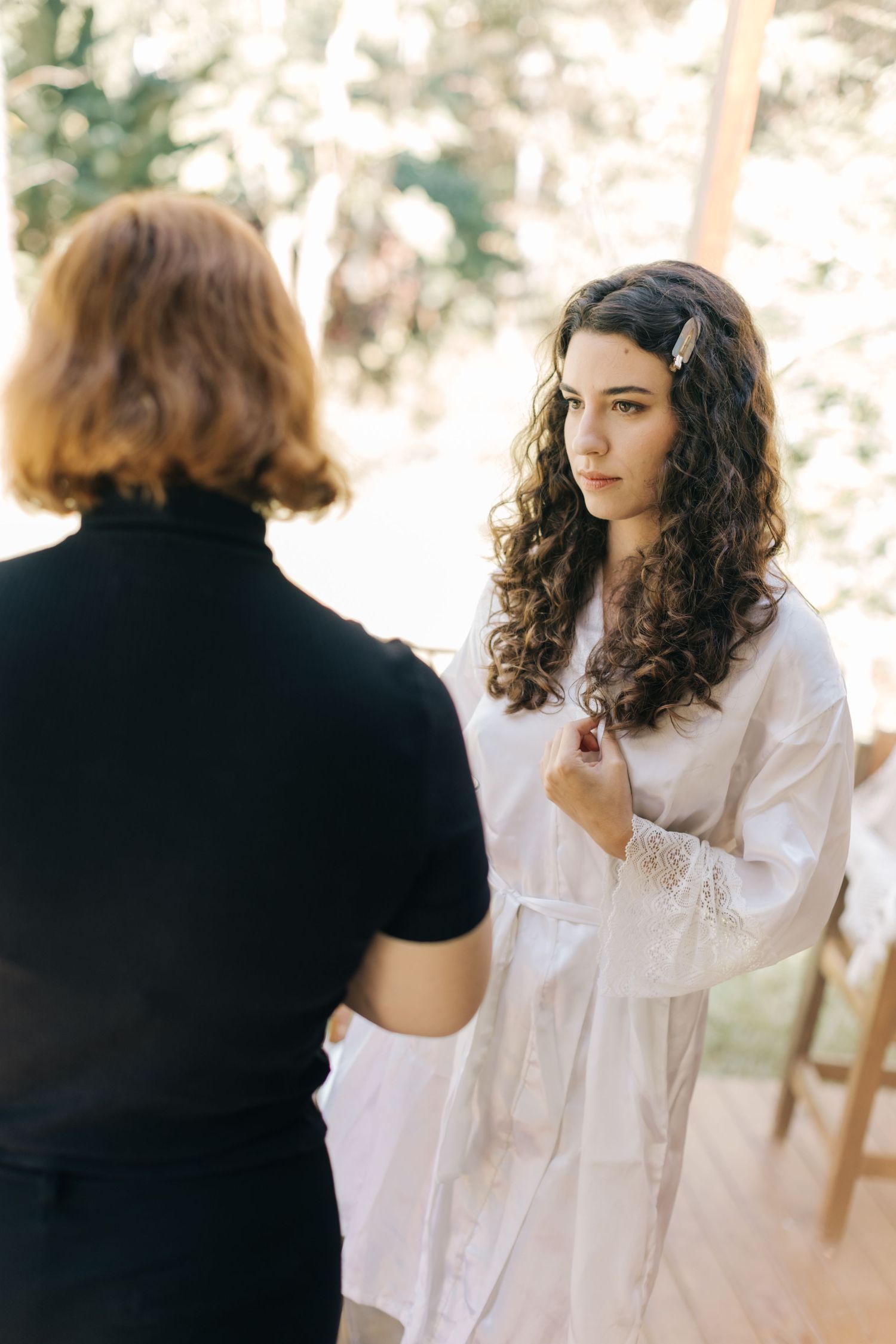 Getting ready scene with person in white robe talking to someone in black.