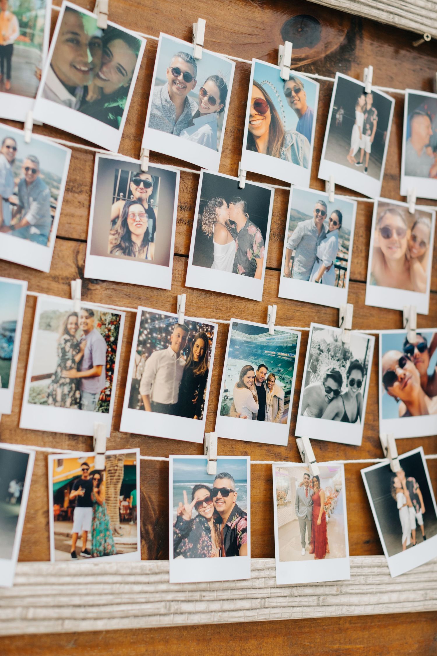 Multiple polaroid photos arranged on a wooden wall display capturing candid moments and memories.