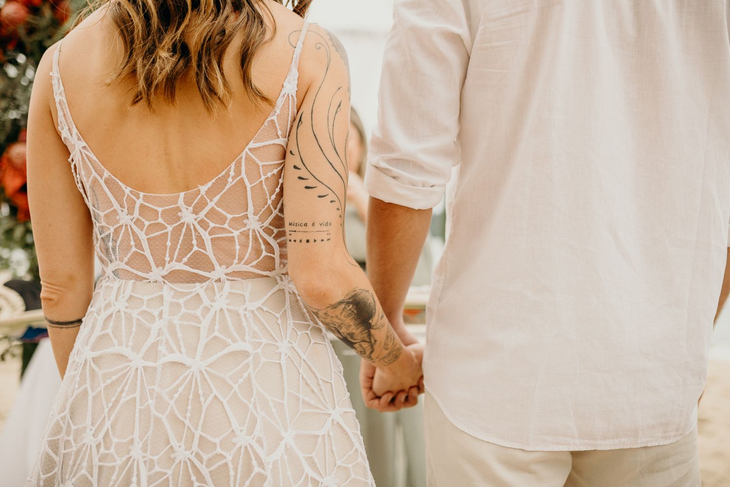 Elegant lace detailed wedding dress pattern shown in close-up at an outdoor celebration.