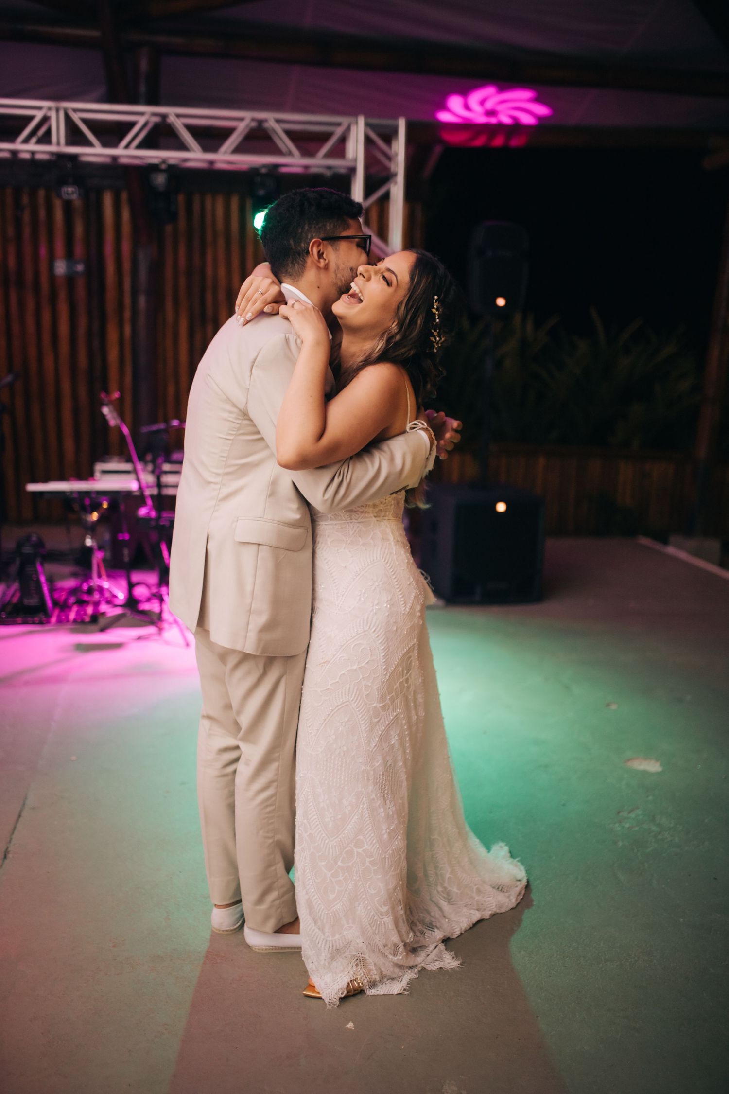 Couples share romantic dances on a colorfully lit reception dance floor.