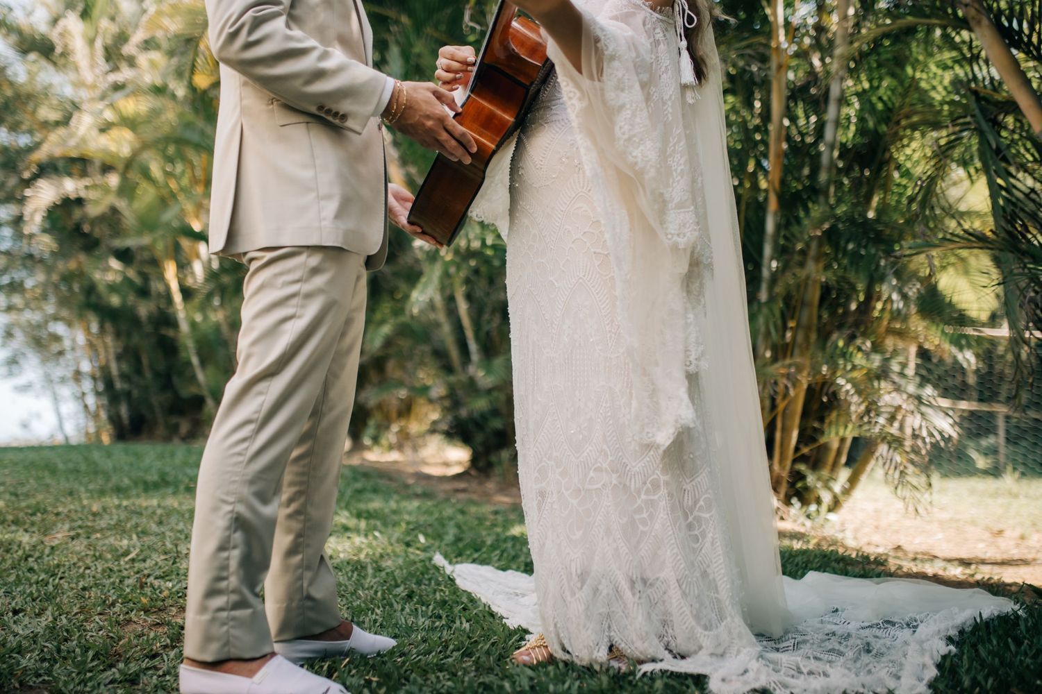 Couple sharing a musical moment with guitar during their garden wedding.