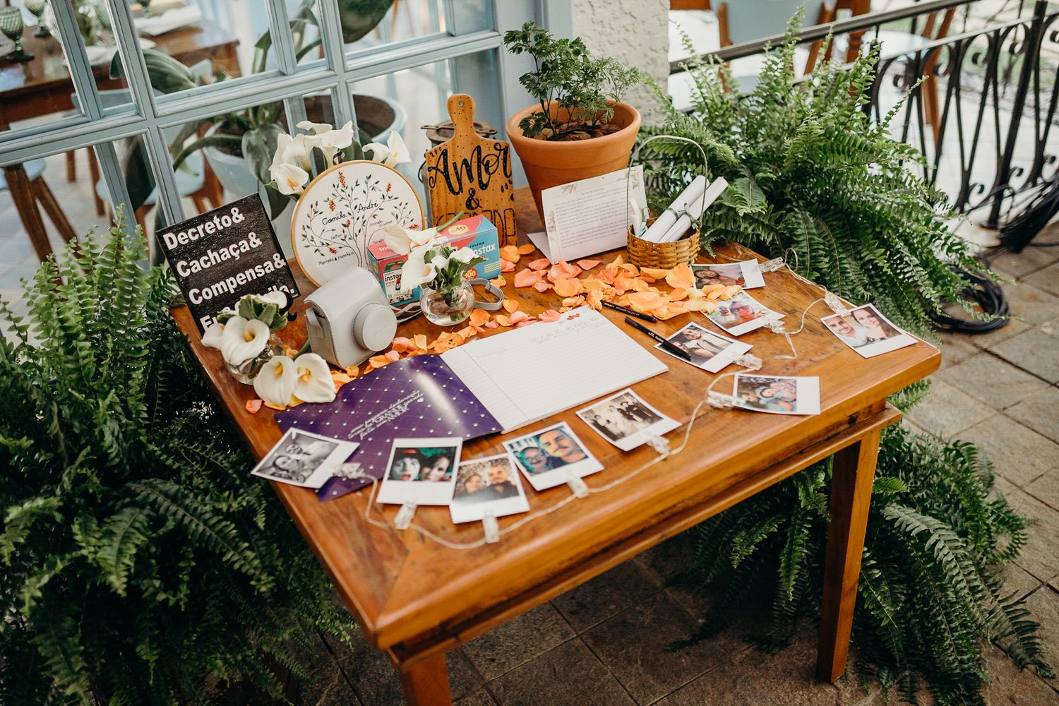 Wedding memory table decorated with vintage photos, plants and personalized decor.