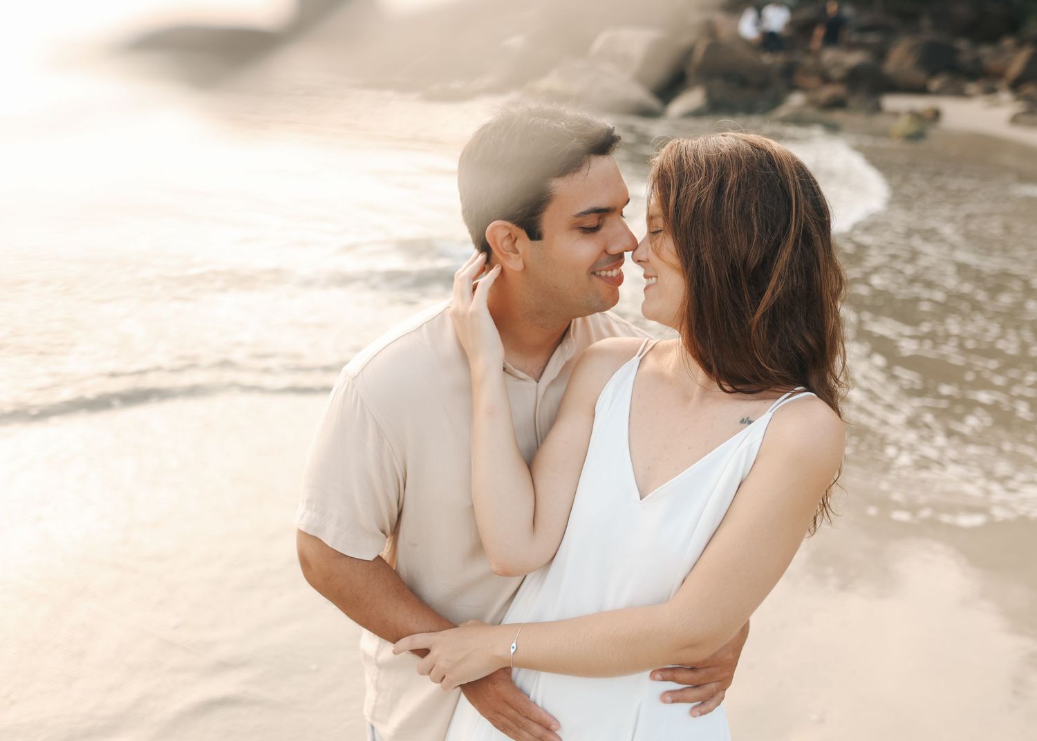 A sweet embrace captured during a beach photoshoot at golden hour.