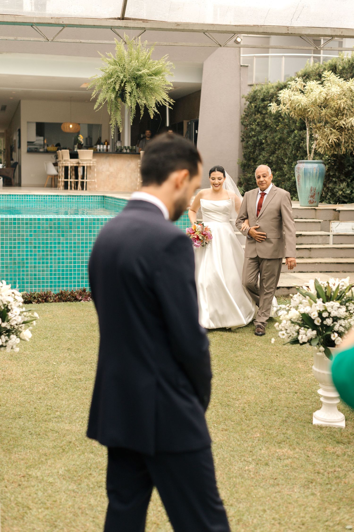 Outdoor wedding ceremony with decorative floral arrangements and manicured lawn.