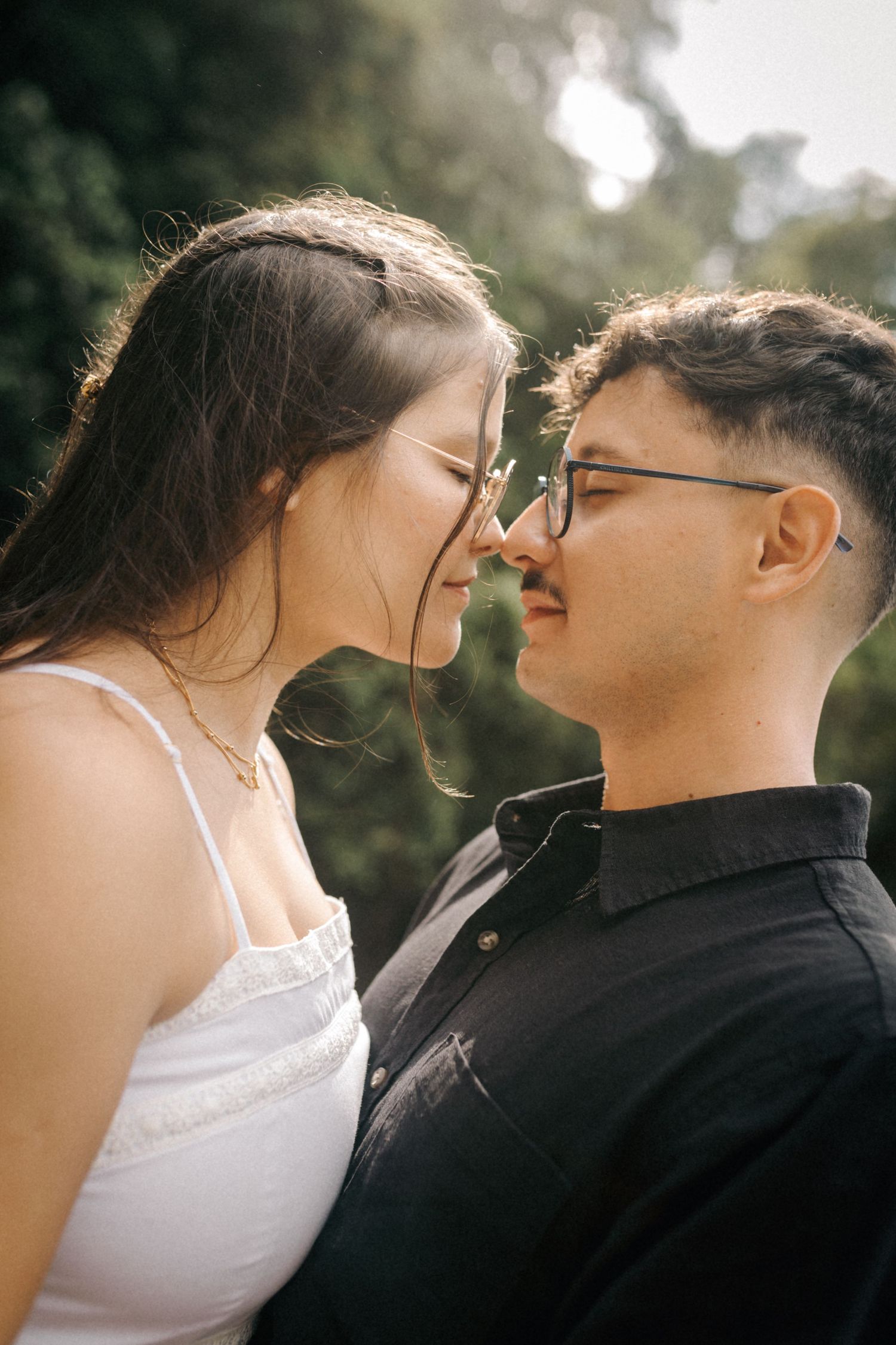 Intimate close-up portrait captured in warm sunlight through trees.