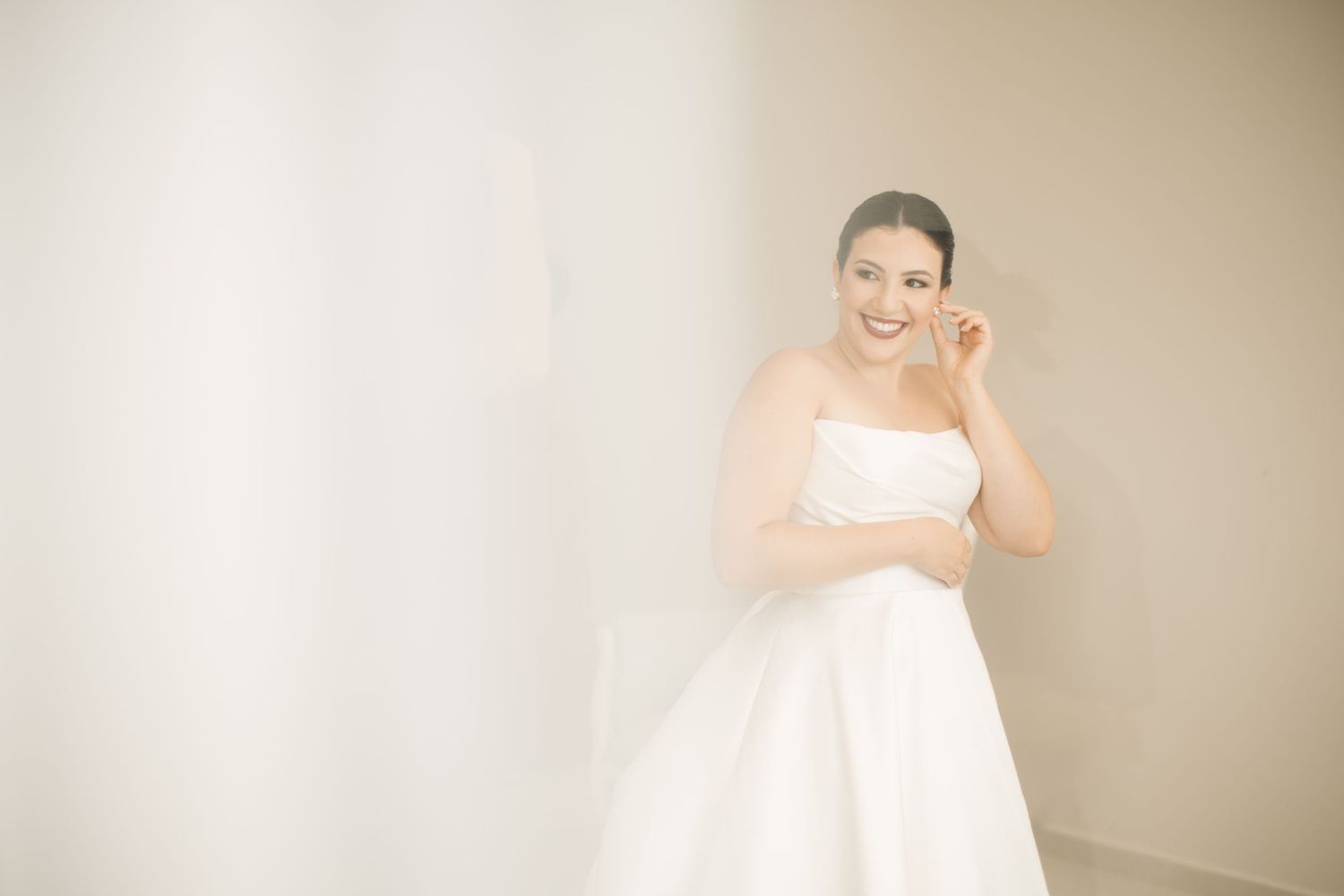 Ethereal bridal portrait in a minimalist setting with soft natural light.