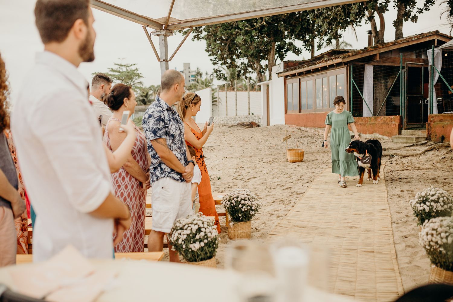 Wedding celebration on a beachfront patio with tropical decor and white tent.