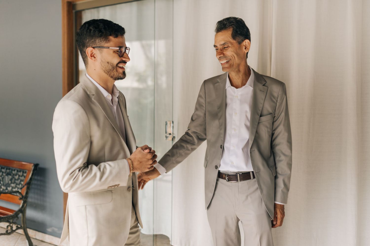 Two people in formal attire sharing conversation in bright interior setting.