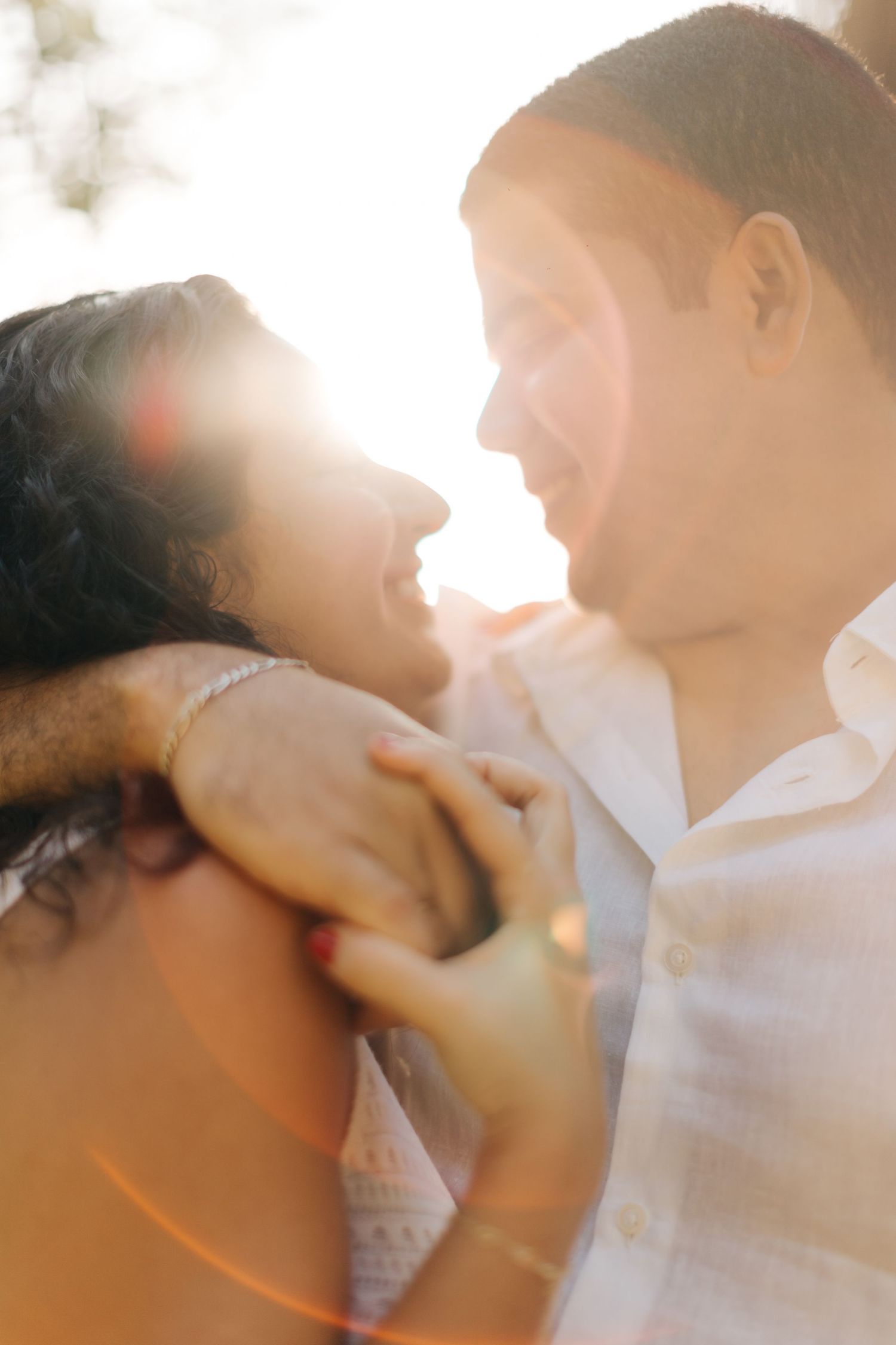 Romantic couple sharing tender moment in glowing sunlight.