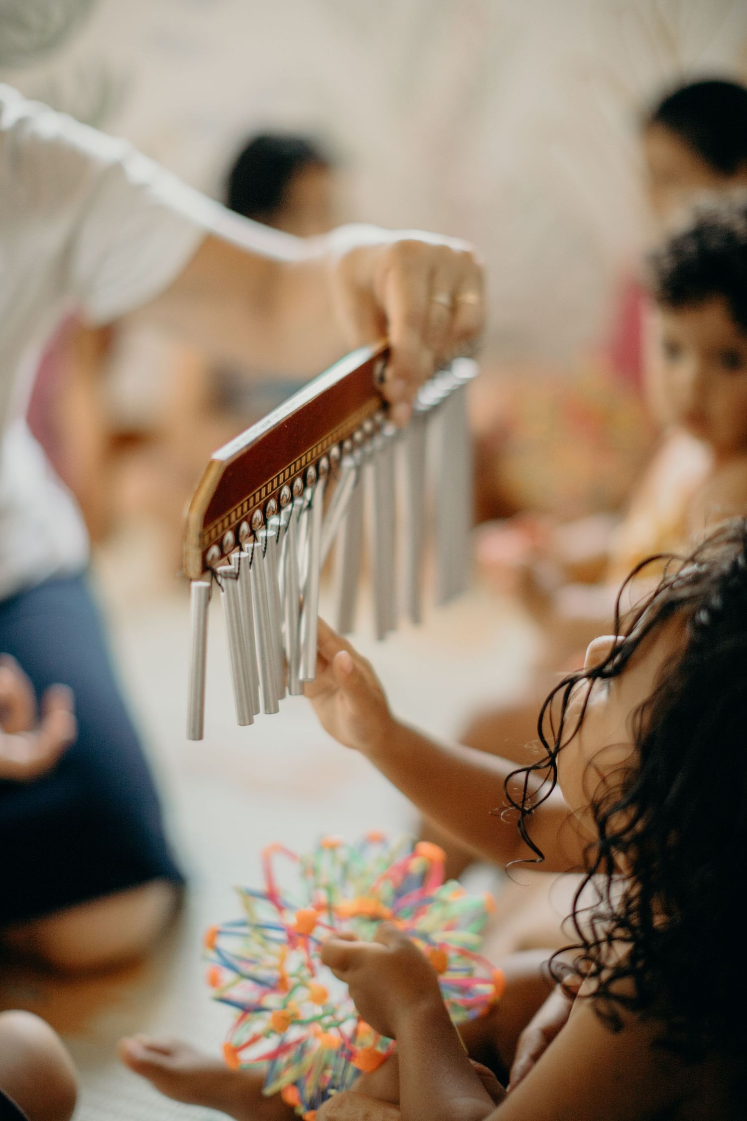 Close-up of hands playing with metal chimes during a music therapy session.