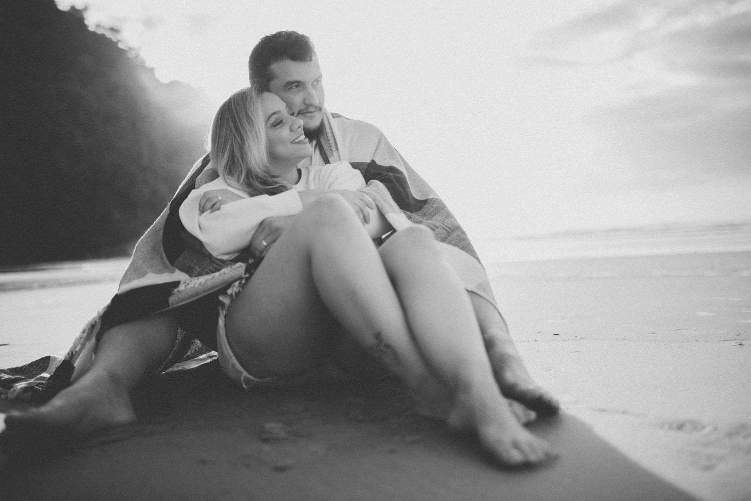 A romantic beach photo of a couple sharing a joyful moment together.