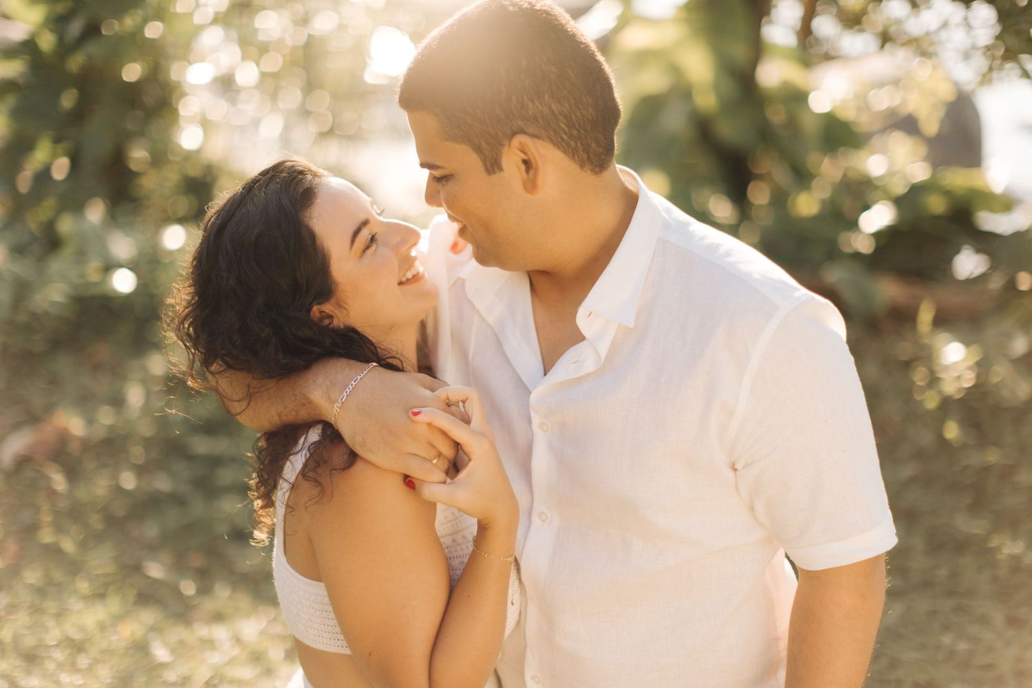 Happy couple sharing romantic moment outdoors in natural lighting.
