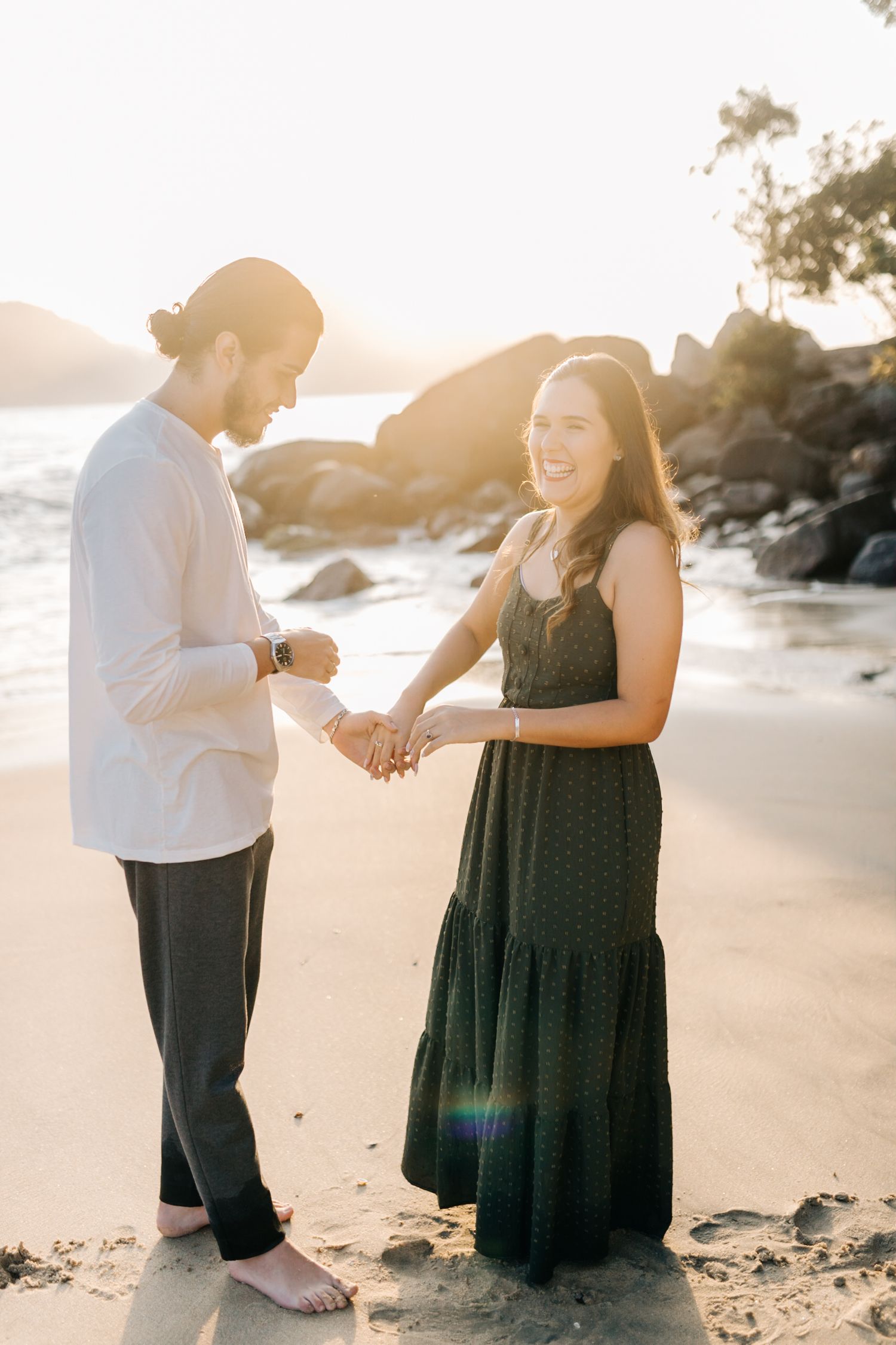 Joyful couple sharing romantic moment on beach during proposal.