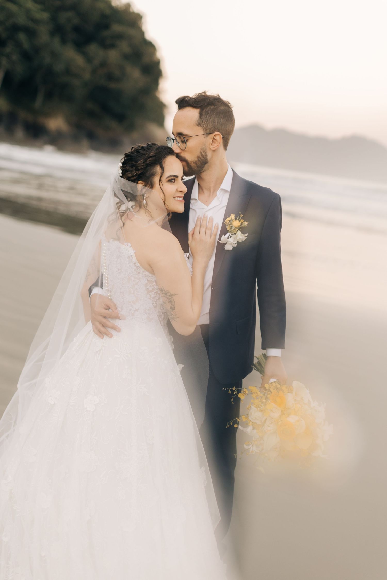 Ethereal beach wedding portraits with soft focus and natural lighting.