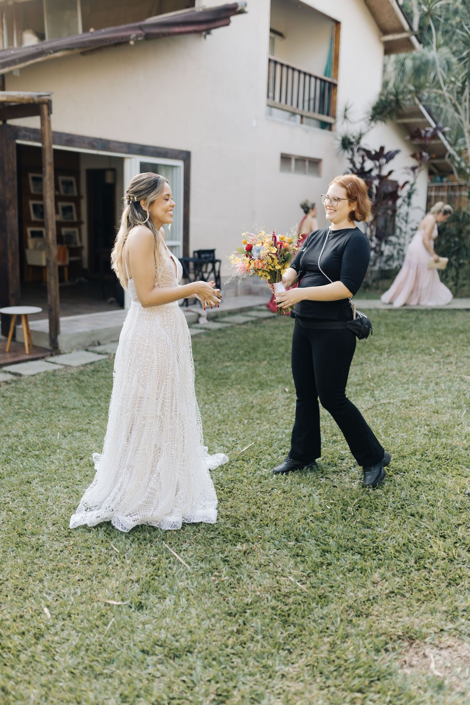 Wedding celebration scene on a green lawn with guests and decorative elements.