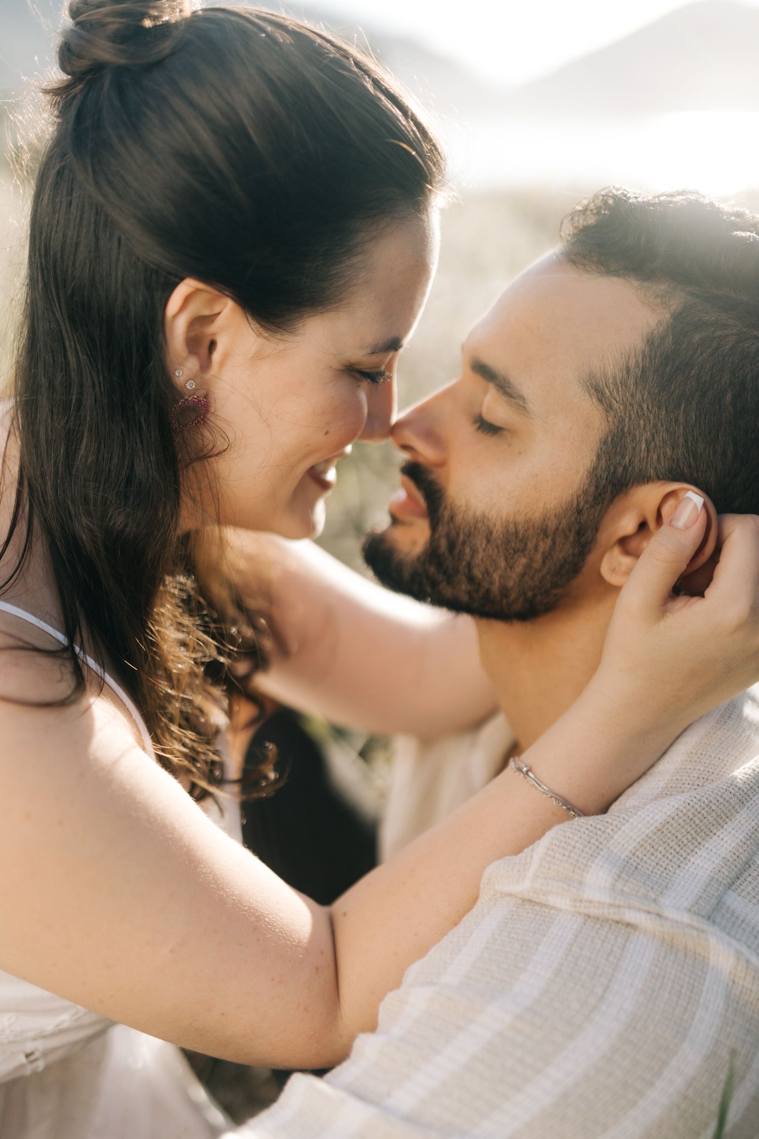 Intimate close-up of couple sharing tender moments in warm natural lighting.