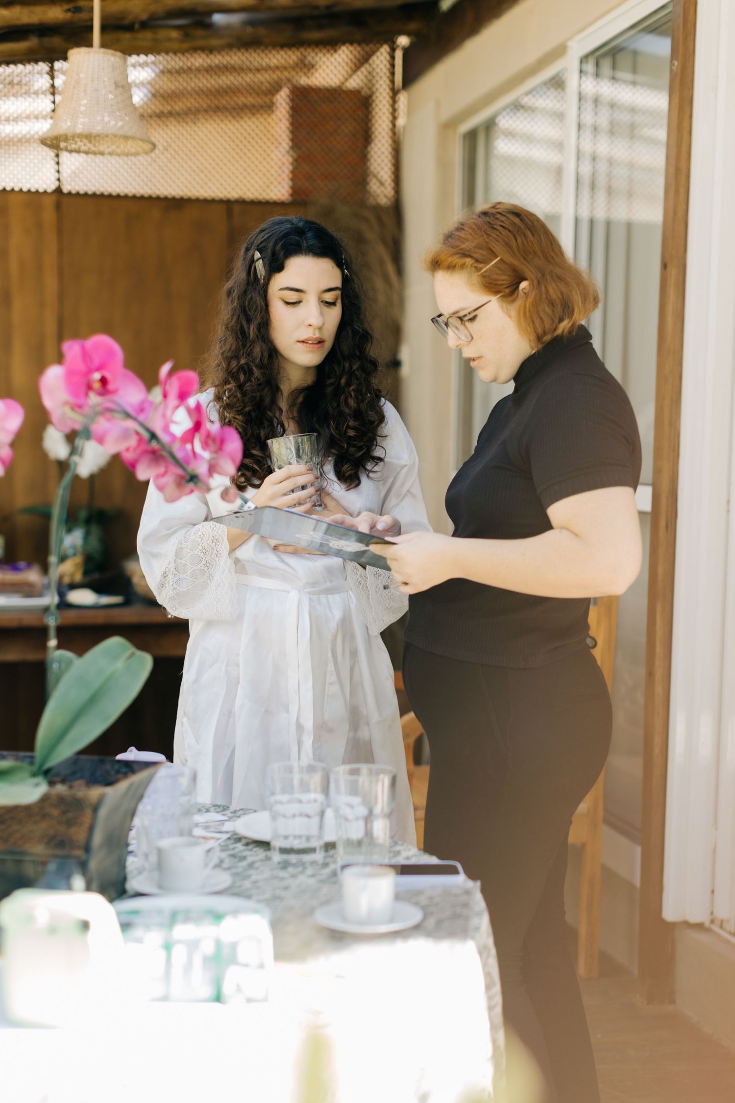 Two people examining a white wedding dress during a dress fitting appointment.