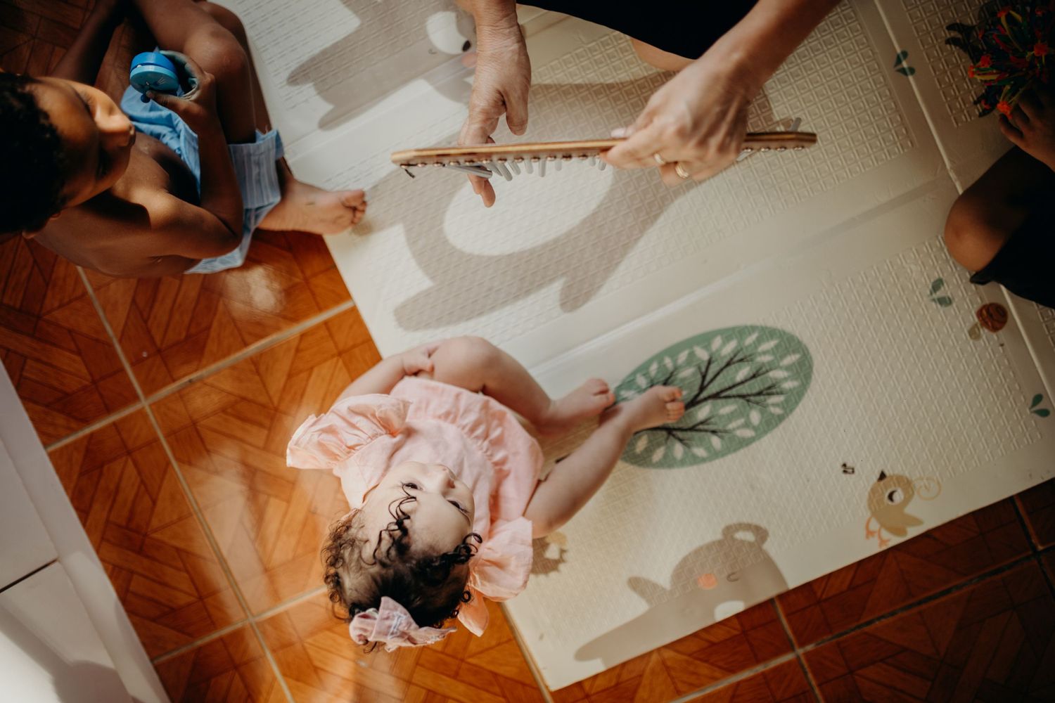Birds-eye view of musical activity on patterned play mat with instruments.