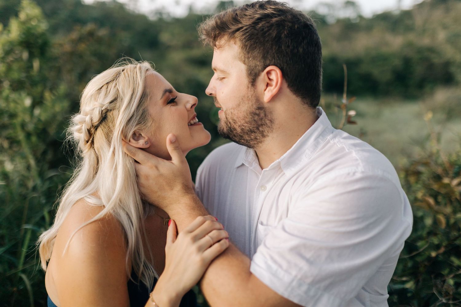 Intimate close-up of couple sharing tender moment in natural outdoor setting.