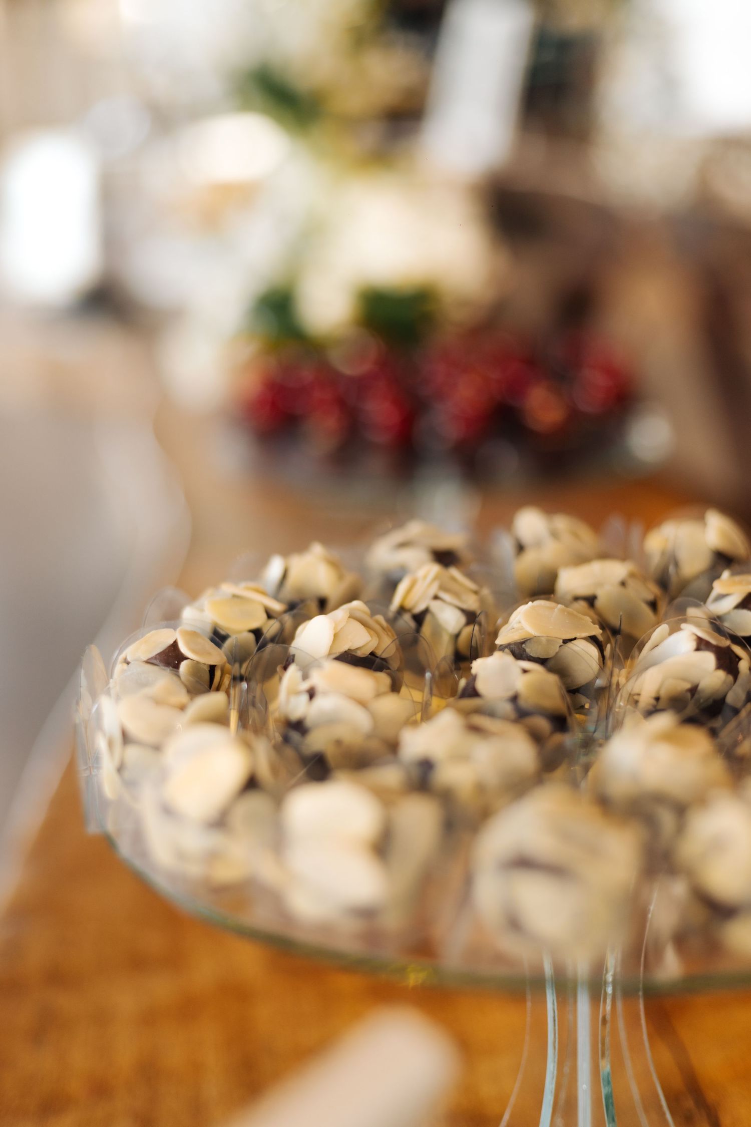 Decorative dessert truffles arranged on a glass serving platter at a wedding reception.