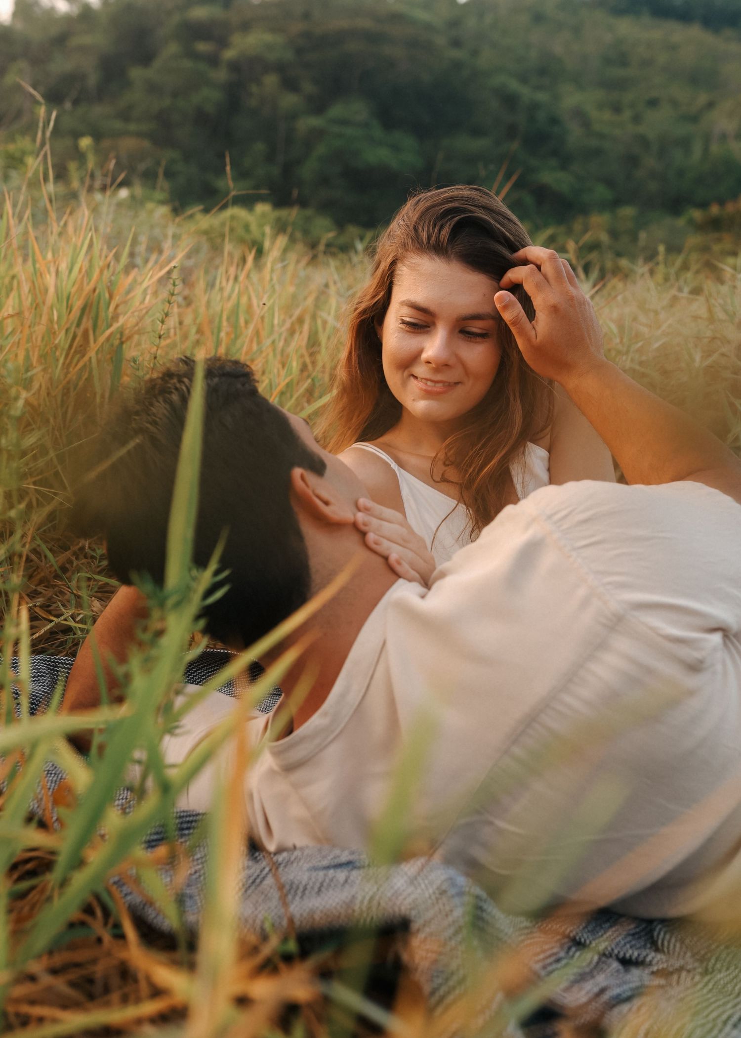 Casual outdoor portrait session in a grassy field with natural lighting.