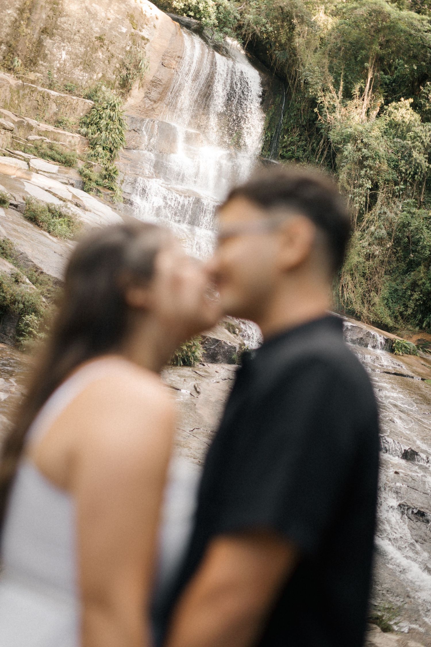 Artistic series of blurred photos showing a couple near a cascading waterfall.