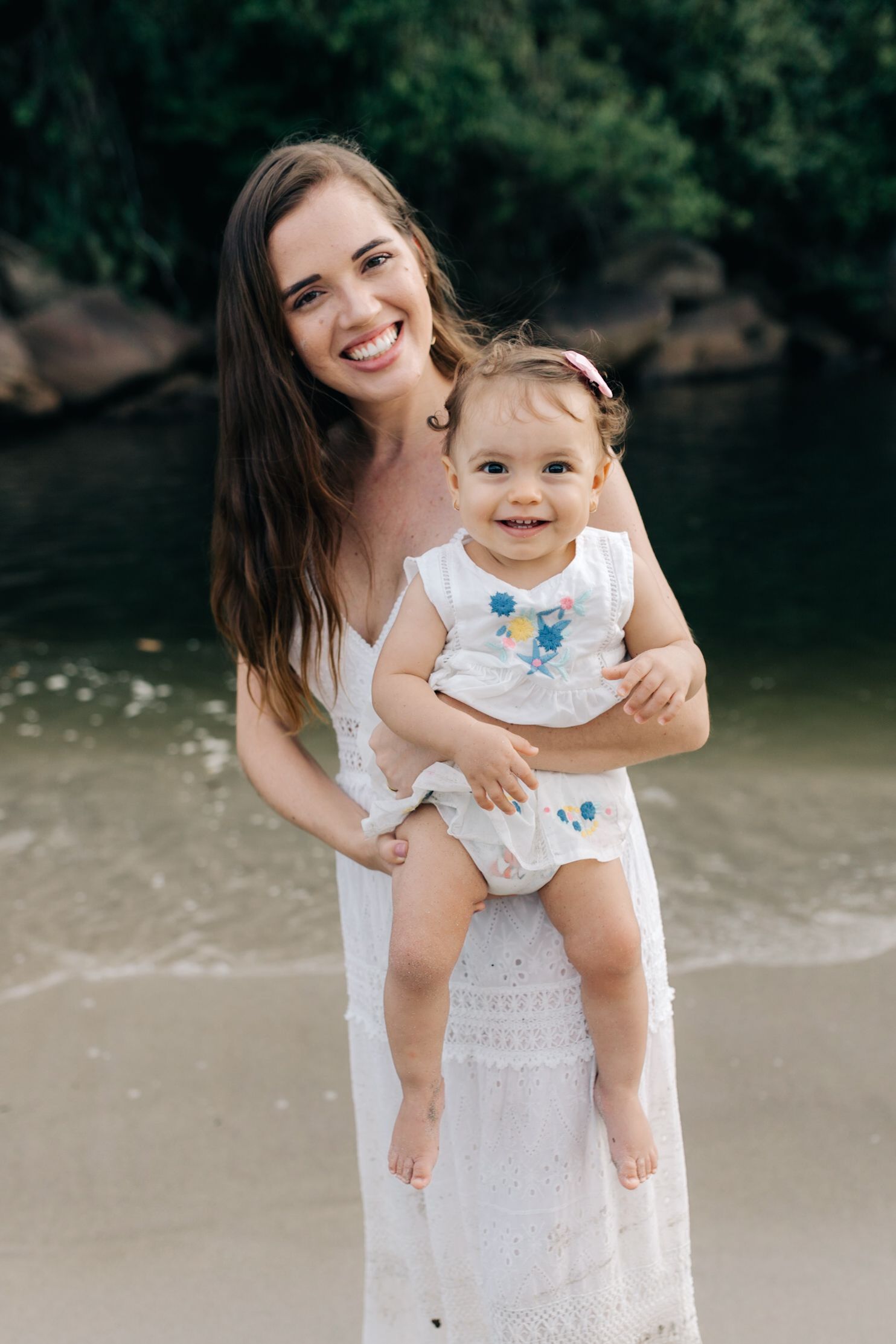 A heartwarming moment shared between parent and baby on a sunny beach.