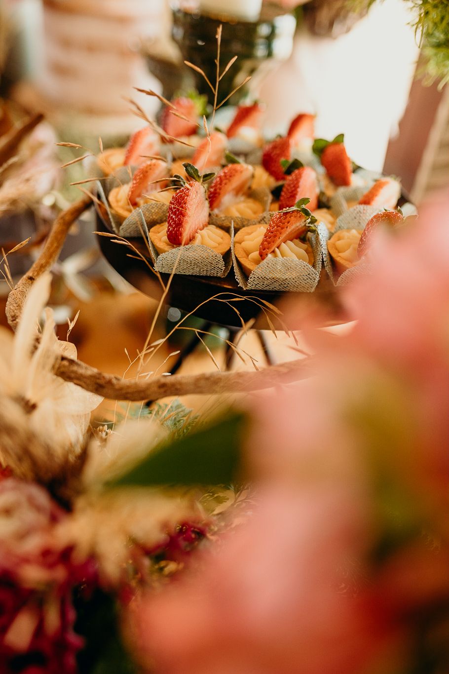 Close-up of appetizers with strawberries and herbs arranged on decorative plates.