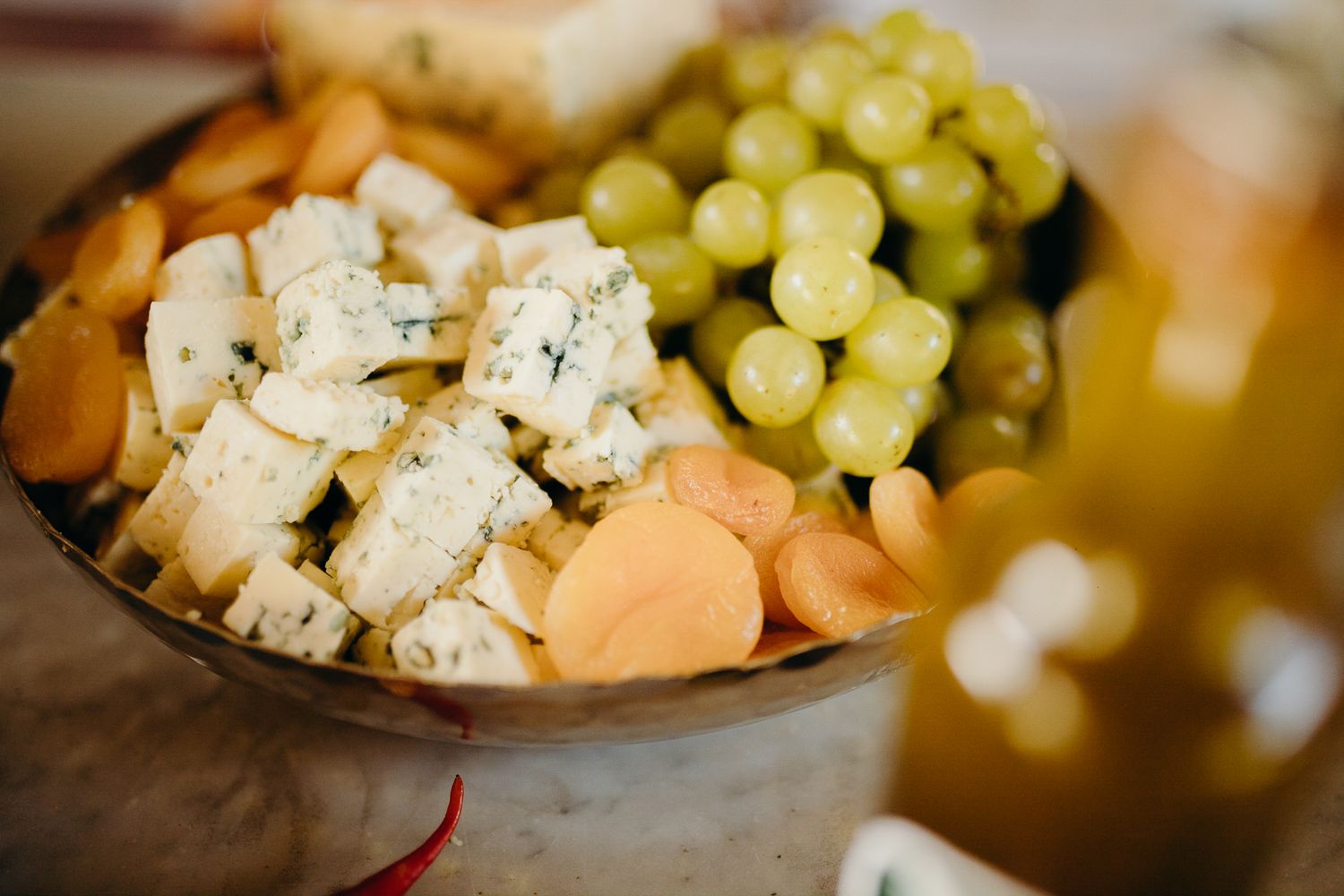 A bowl of cubed cheese and fresh grapes arranged as an appetizer platter.