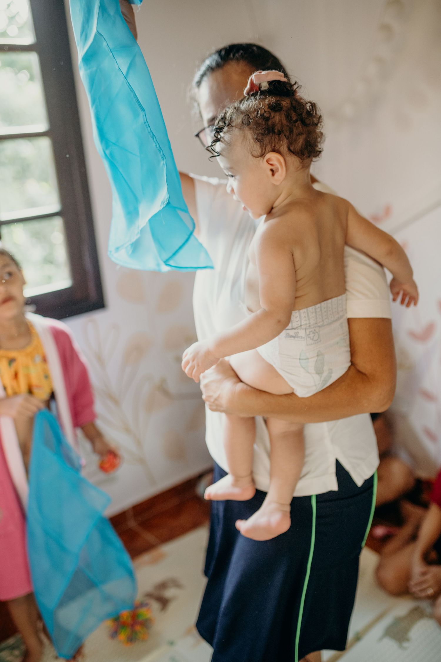Indoor play session with fabric decorations and family interactions.