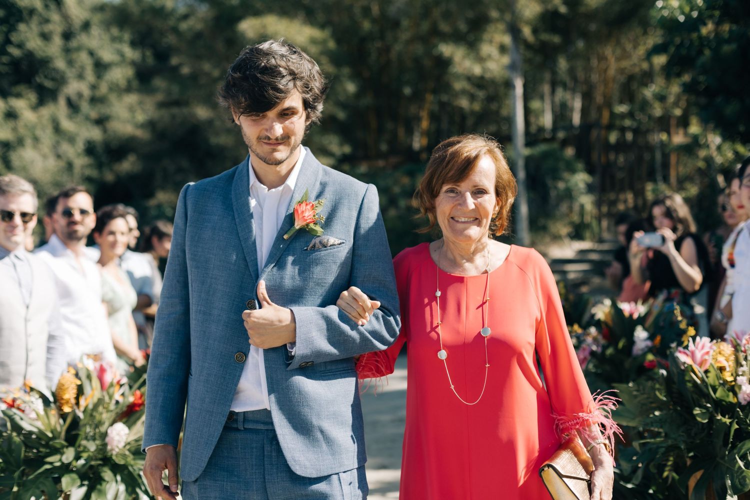 Wedding guests enjoying a casual outdoor celebration with coral and blue attire.