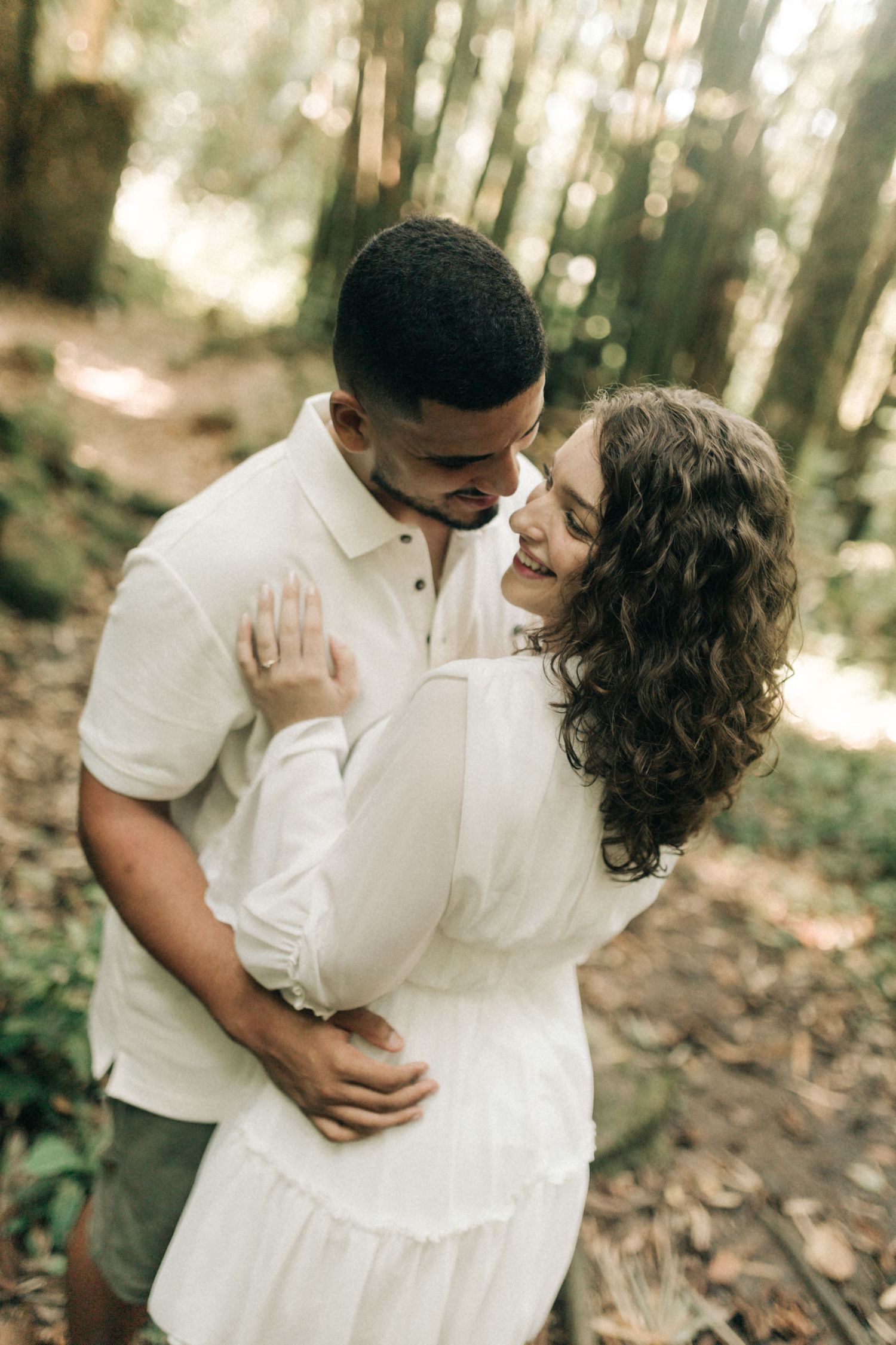 Intimate couple's portrait session captured in soft natural lighting within a serene forest setting.