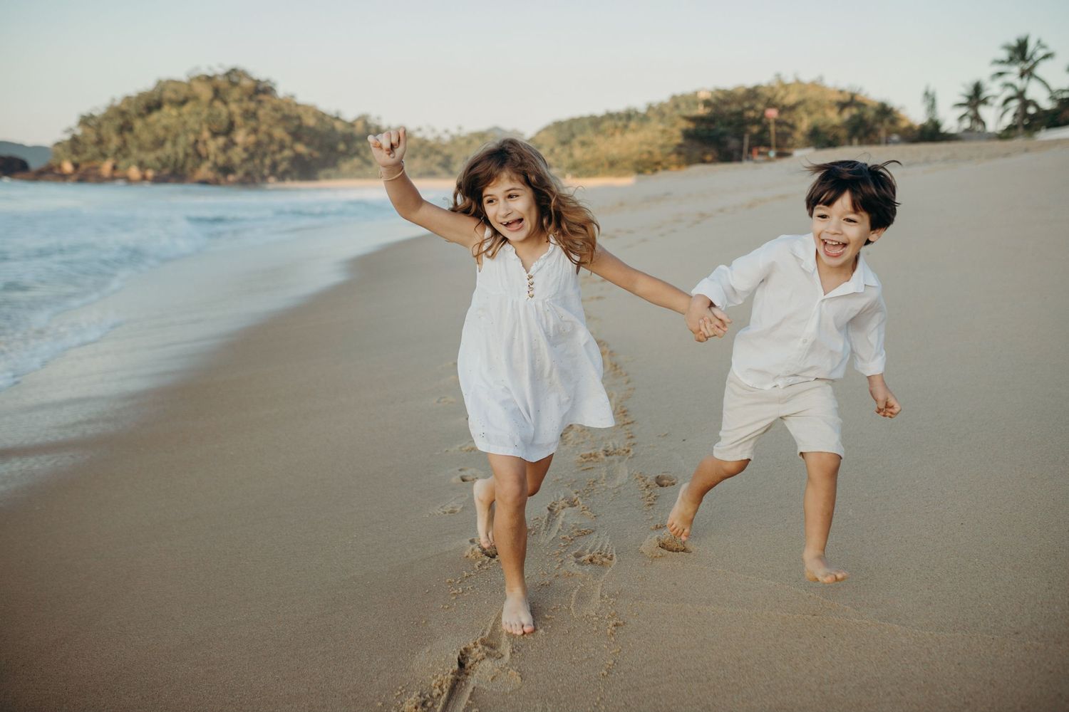 Children skipping and playing together on a beautiful coastal beach.
