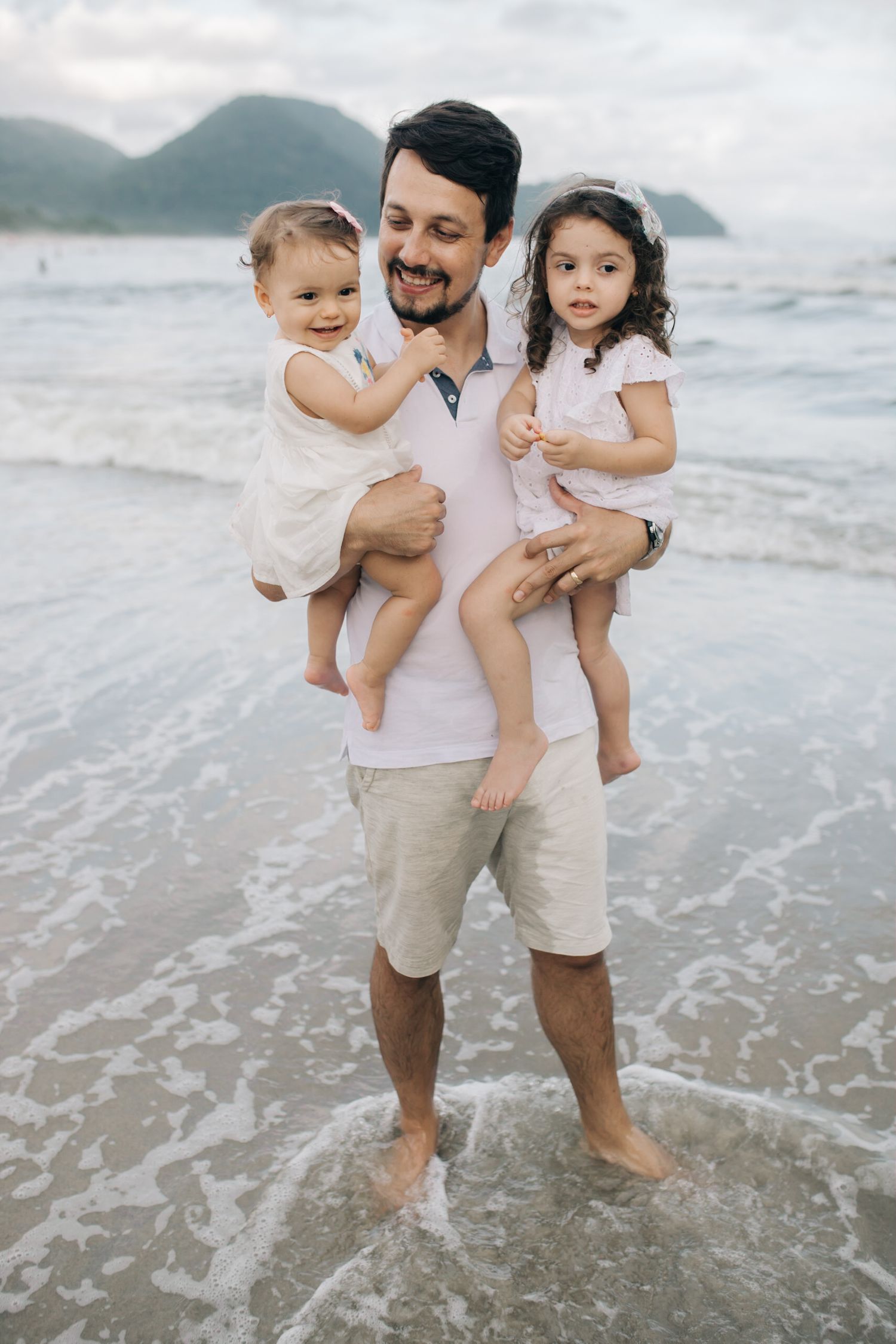 A family shares playful moments together at the water's edge.