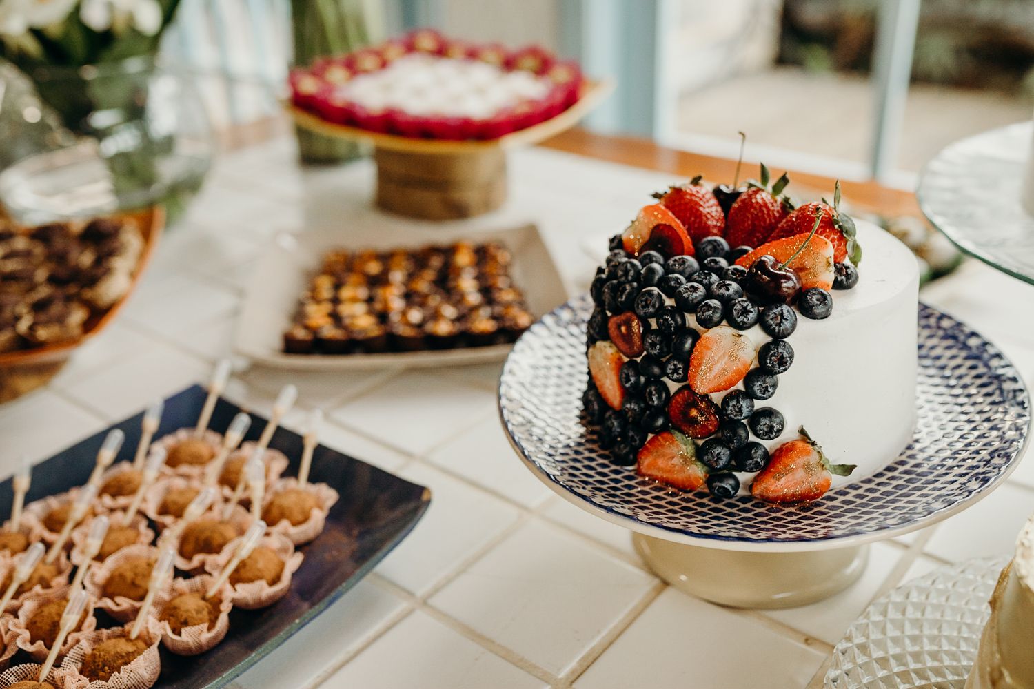 Close-up of wedding dessert table with fresh berries and ornate plating.