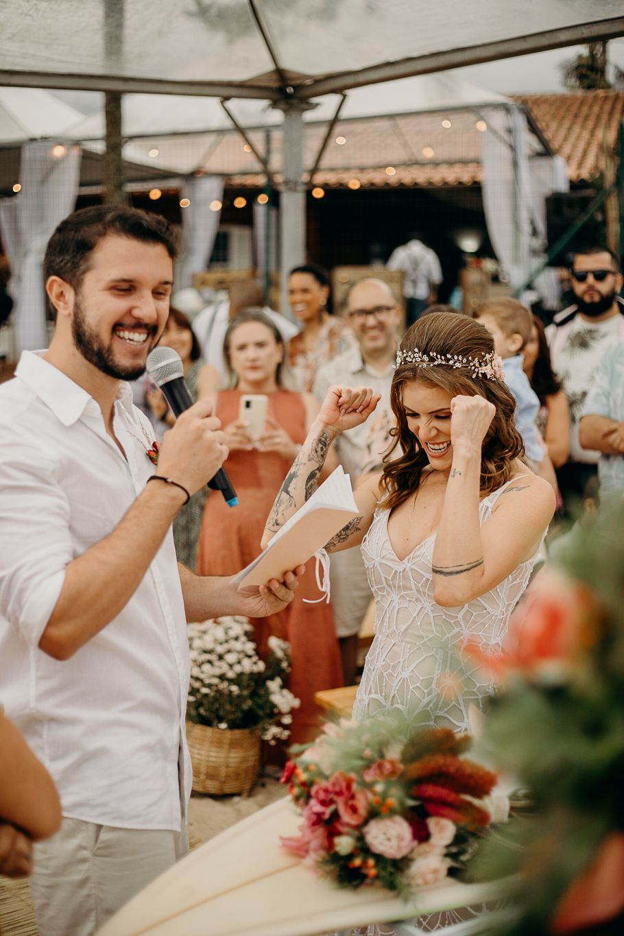 Festive outdoor wedding reception with guests celebrating and raising glasses in a toast.