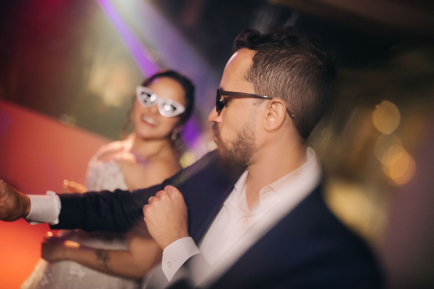 Wedding celebration with blurred lights and dancing silhouettes in warm tones.