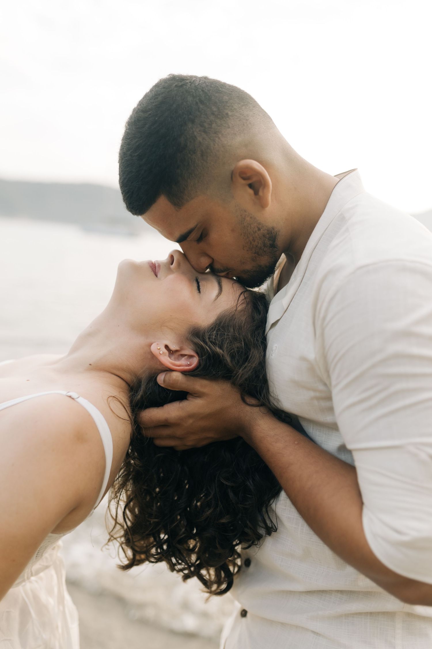 A romantic close-up of a couple sharing an intimate moment on the beach.