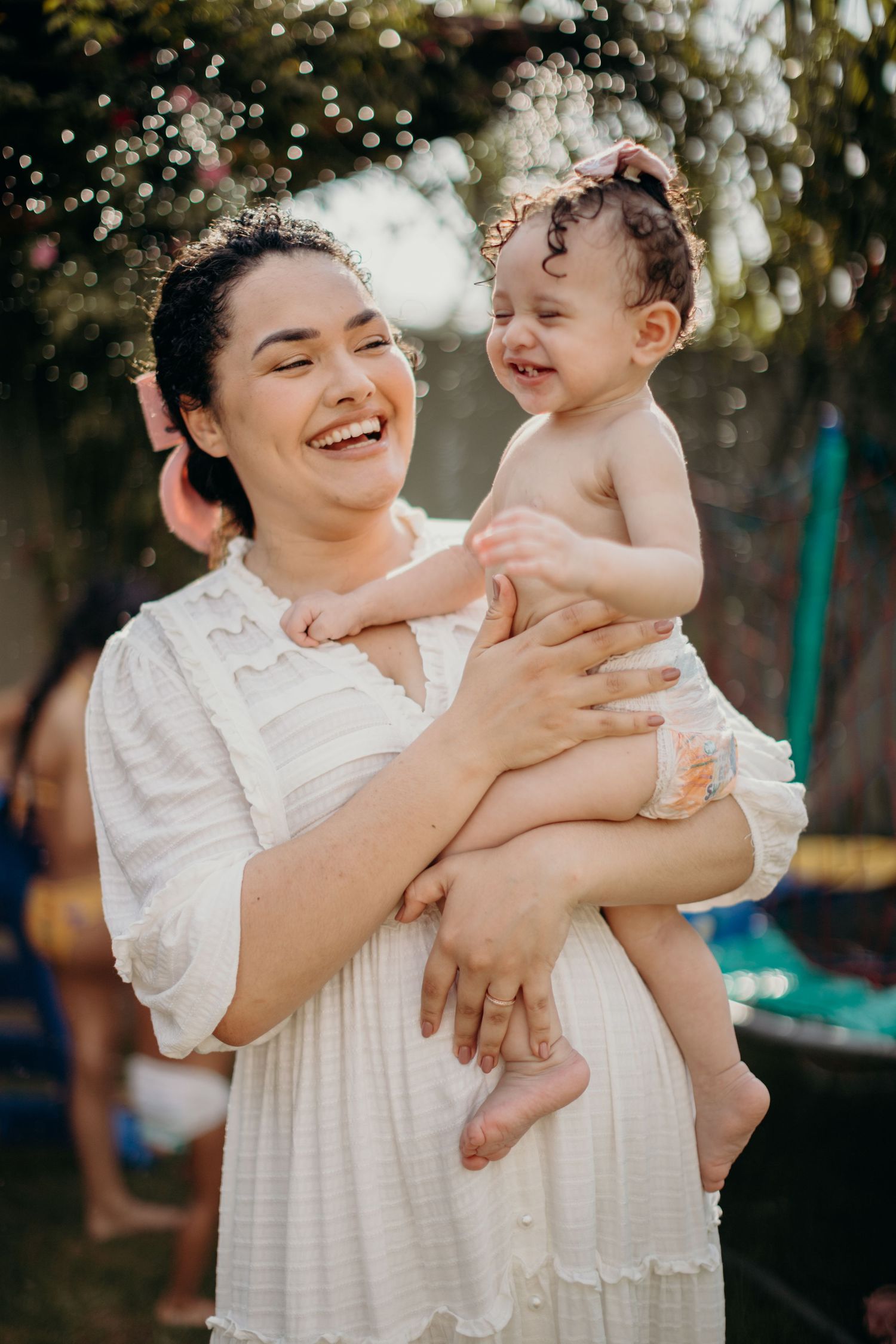 A joyful outdoor moment between parent and child against a bokeh background.
