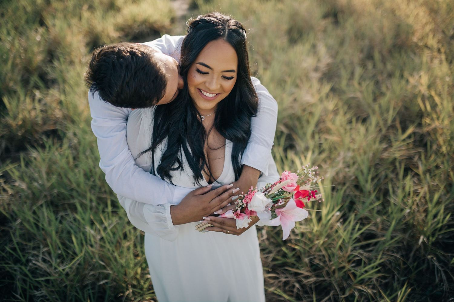 Couple sharing joyful moments during an outdoor photography session in natural settings.