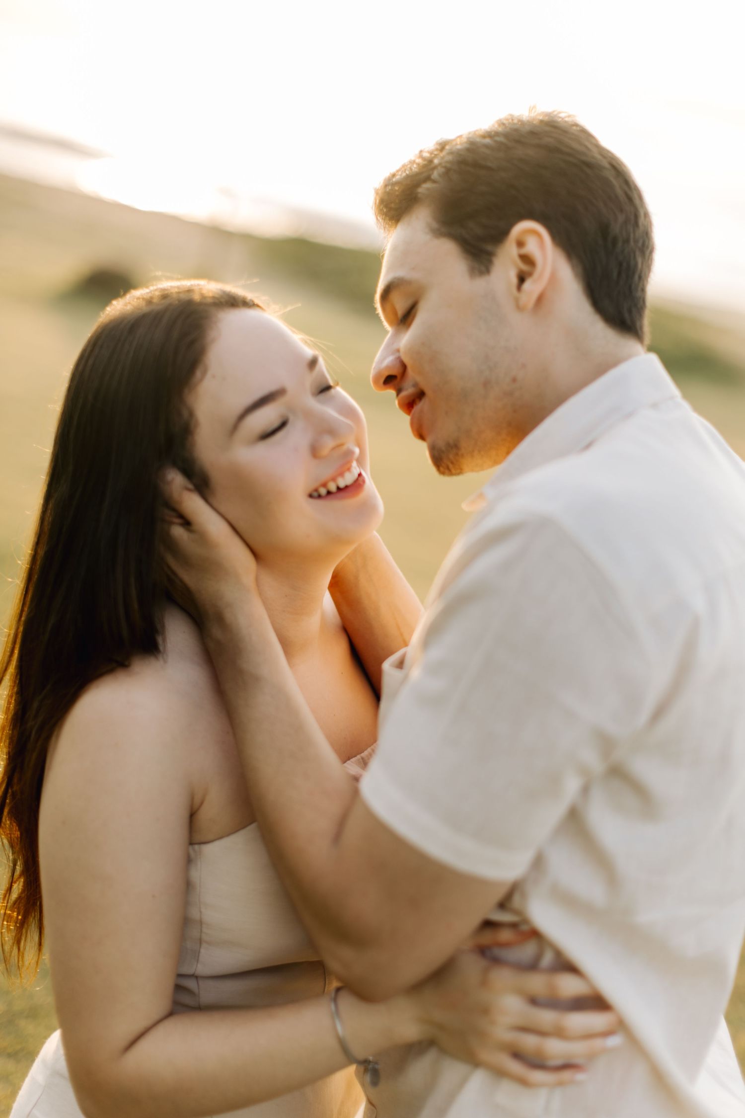 Candid moment of couple laughing and embracing during golden hour photoshoot.